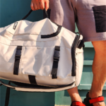SUPOTSU sporty lightweight backpack in white, worn crossbody or as a backpack with padded shoulder straps.
