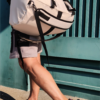 SUPOTSU sporty lightweight backpack in white, worn crossbody or as a backpack with padded shoulder straps.