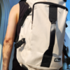 SUPOTSU sporty lightweight backpack in white, worn crossbody or as a backpack with padded shoulder straps.