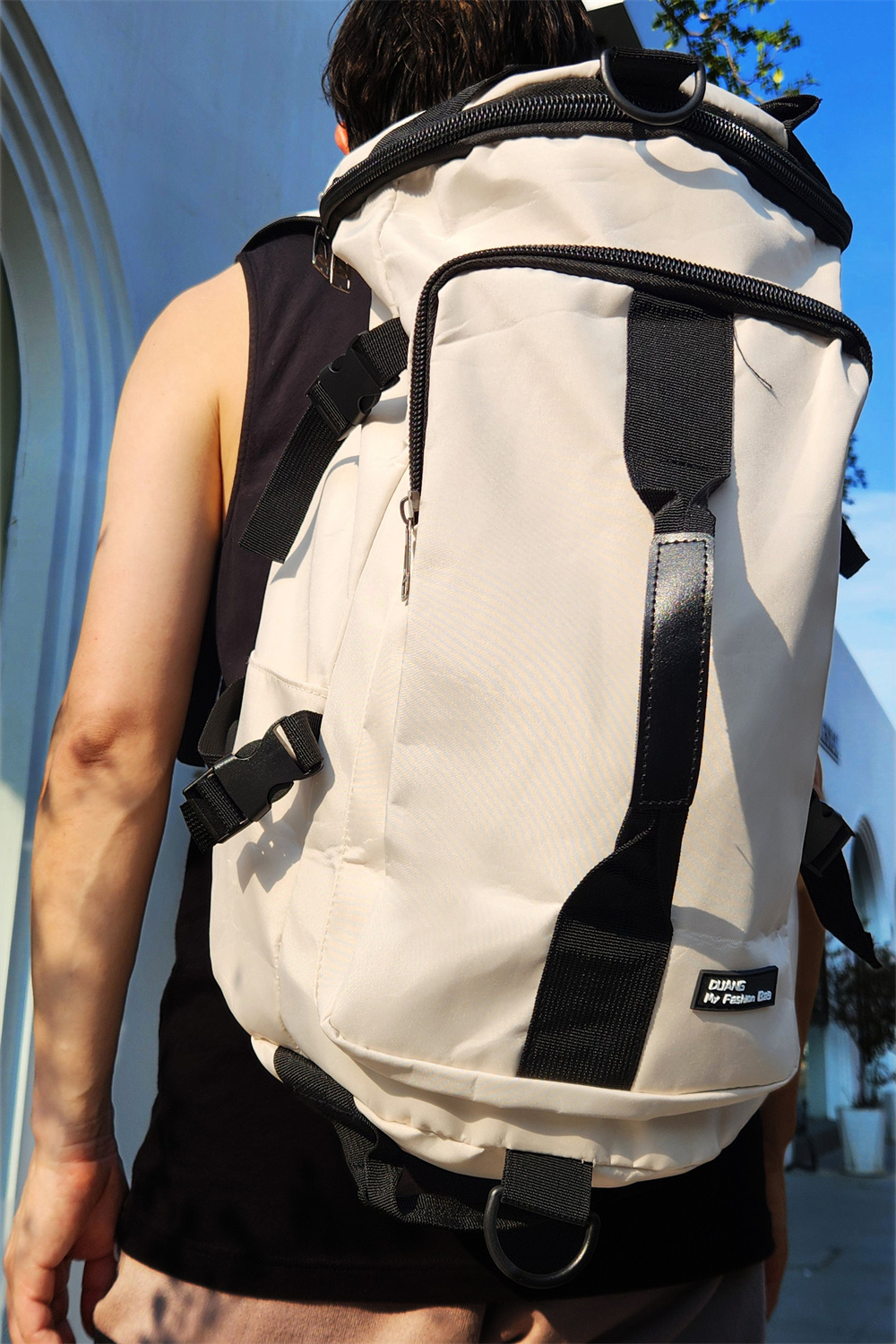 SUPOTSU sporty lightweight backpack in white, worn crossbody or as a backpack with padded shoulder straps.