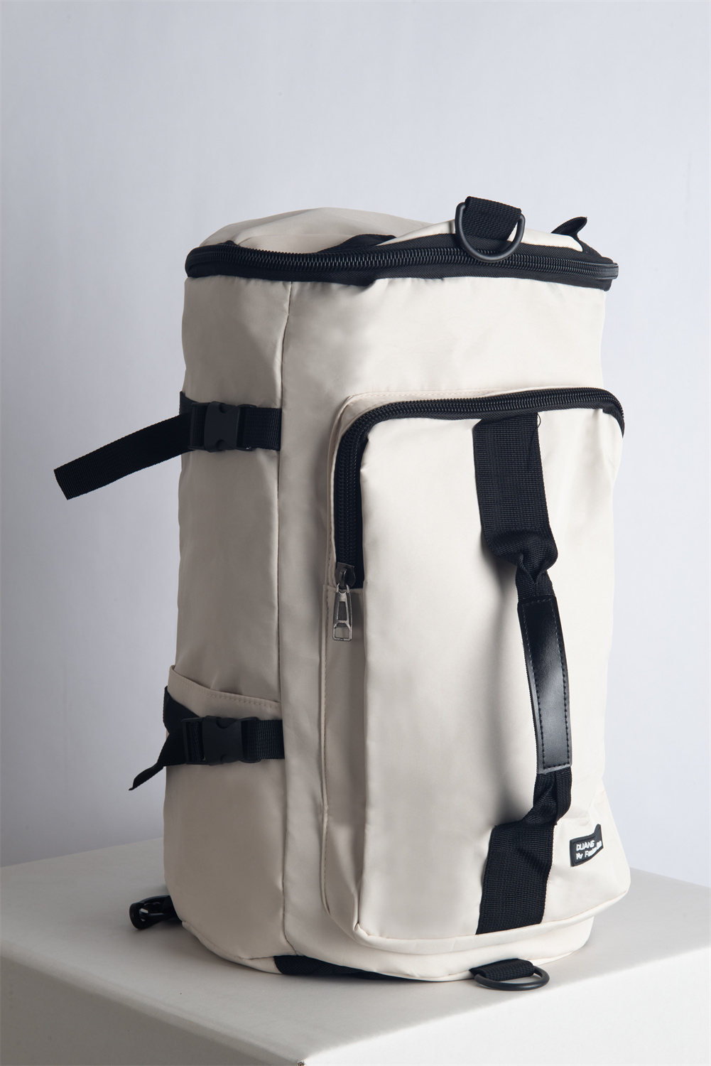SUPOTSU sporty lightweight backpack in white, worn crossbody or as a backpack with padded shoulder straps.