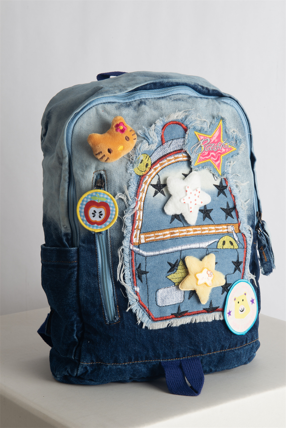 JINZU is a stylish medium-sized denim backpack adorned with playful, colorful pins—perfect for adding whimsy to your look. Lightweight and well-compartmentalized, it keeps your essentials organized whether you're heading to class or a casual party.