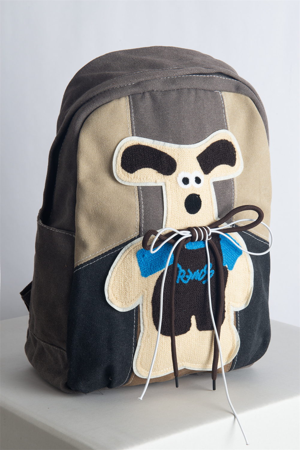KANGA is a cute and playful backpack featuring a gray and beige colorway, a unique kangaroo print, and a secure back iPad pocket—perfect for autumn and winter fashion.