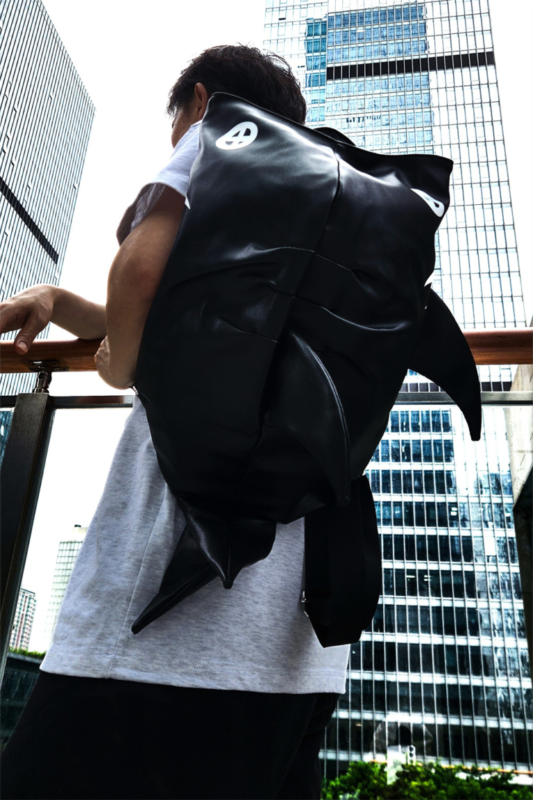 Make a bold statement with the SHARK-SAN backpack. Featuring a striking shark-inspired design and crafted from lightweight, waterproof material, this compact bag offers just enough room for your phone, wallet, and a small water bottle—perfect for casual meetups and stylish adventures.