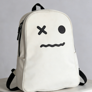 A white water-resistant school backpack called HAKU featuring a funny face design with an X-shaped eye, multiple compartments, and adjustable padded straps.