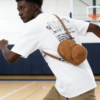 An American high schooler wearing the HATTO mustard yellow mini crossbody bag while playing basketball.