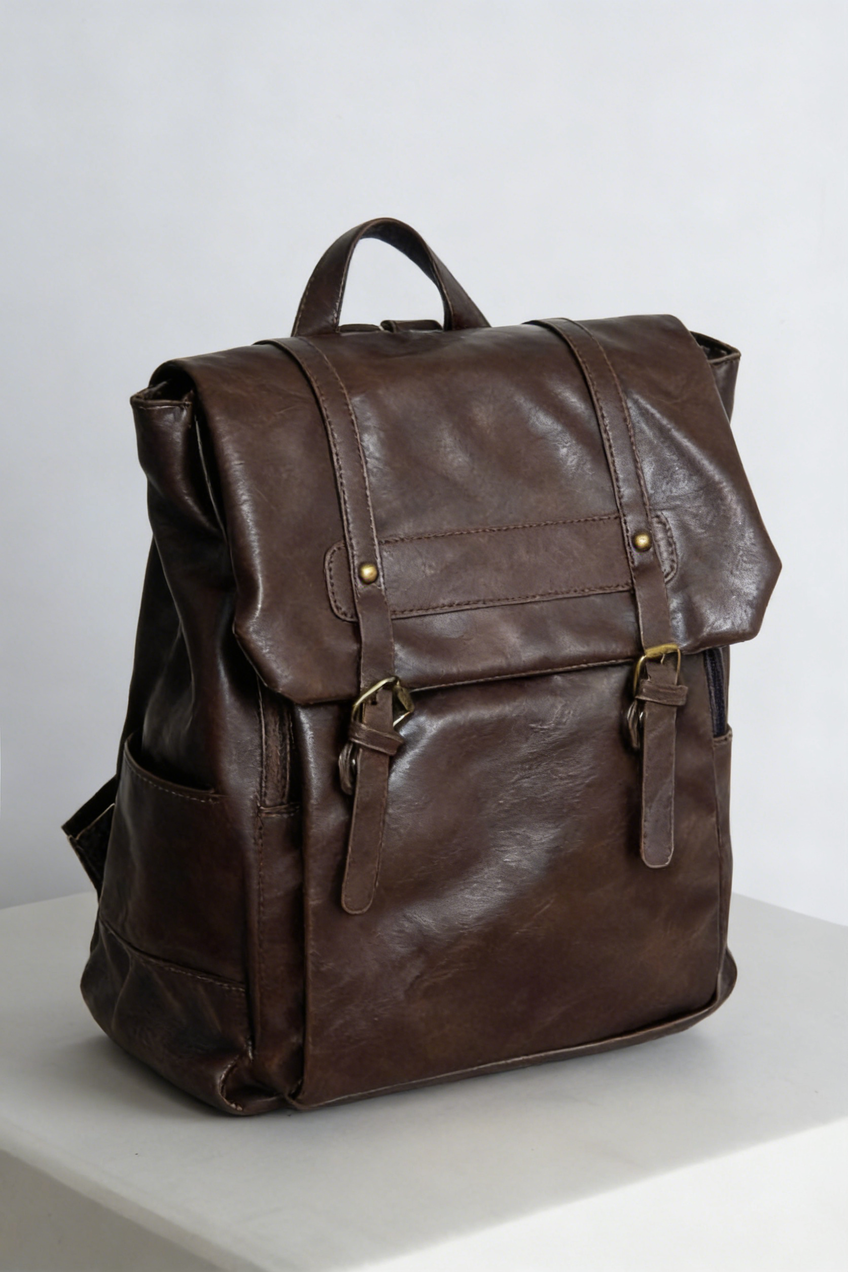 Waterproof PU leather backpack in brown, dark academia style perfect for work, school, and travel. Waterproof and wear-resistant, keeps the vintage look fresh. Backpack has many compartments, adjustable straps, and fits a 14 inch laptop.